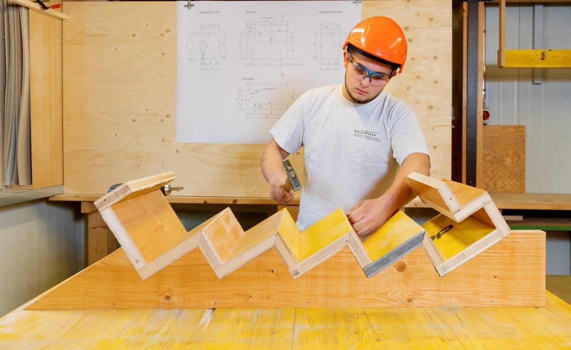Typische Arbeitssituationen von Betonwerkern: Auszubildender fertigt Holzverschalung an.